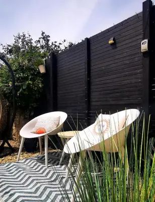 two chairs and a table in front of a fence at Gwynn Lodge in Newquay