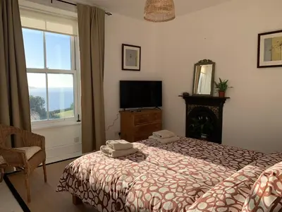 a bedroom with a bed and a tv and a window at The Post House in Charlestown