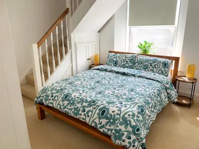 a bedroom with a bed with a blue and white comforter at The Post House in Charlestown