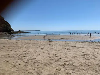a group of people on a beach with the ocean at The Post House in Charlestown