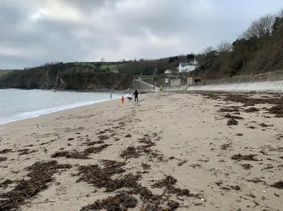 a person and a child walking on a beach at The Post House in Charlestown