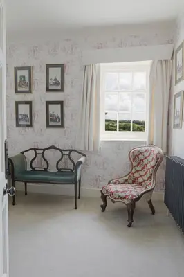 a living room with a chair and a window at Trewardale in Bodmin