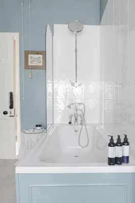 a white bath tub with a shower in a bathroom at Trewardale in Bodmin