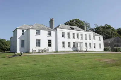 a large white house with a lawn in front of it at Trewardale in Bodmin