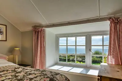 a bedroom with a window with a view of the ocean at Finest Retreats - Lesceave Cottage in Praa Sands