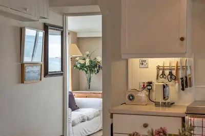 a kitchen with a microwave and a couch in a room at Finest Retreats - Lesceave Cottage in Praa Sands