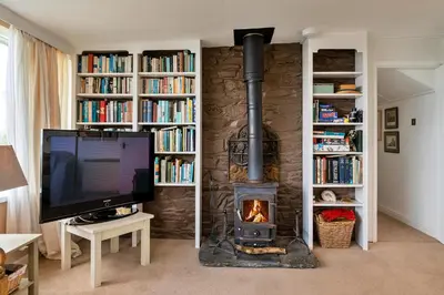 a fireplace in a living room with a tv and a television at Finest Retreats - Lesceave Cottage in Praa Sands