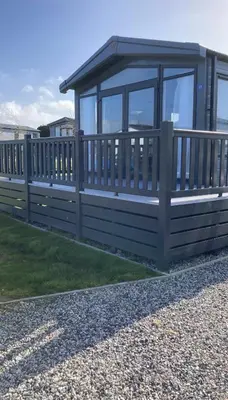 a wooden fence next to a house at Bailey Lodge in Padstow