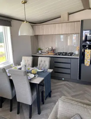 a kitchen with a table and chairs in a kitchen at Bailey Lodge in Padstow