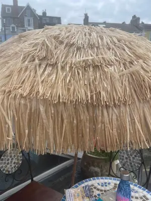 a straw umbrella sitting on top of a table at Harbour View in St Ives