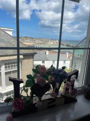 a vase of flowers sitting on a window sill at Harbour View in St Ives