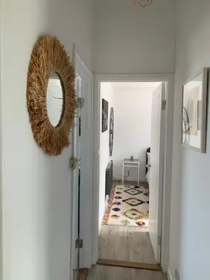 a hallway with a wreath on the wall and a mirror at Harbour View in St Ives