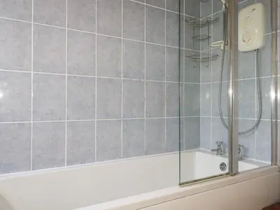a bathroom with a shower and a bath tub at Beachcliff in Gorran Haven