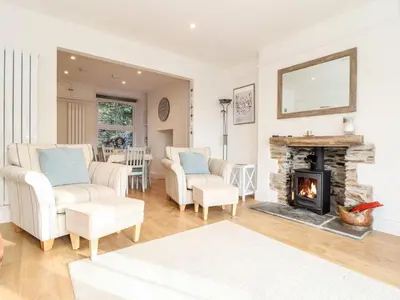 a living room with two chairs and a fireplace at Cliffside in Tintagel