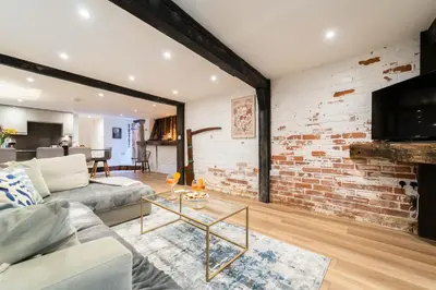 a living room with a couch and a brick wall at The Boathouse in St Ives