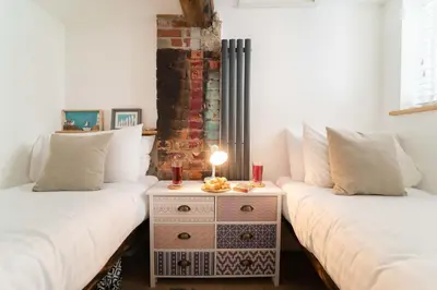 a room with two beds and a table with candles on it at The Boathouse in St Ives