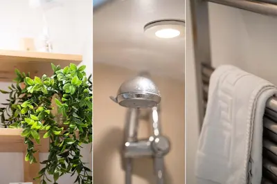 a bathroom with a towel and a light and a plant at Little Waves in St Ives