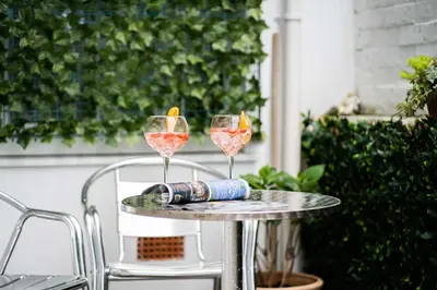 two wine glasses on a table on a patio at Little Waves in St Ives