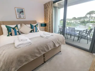 a bedroom with a large bed and a table with chairs at Sebastian's View in Falmouth