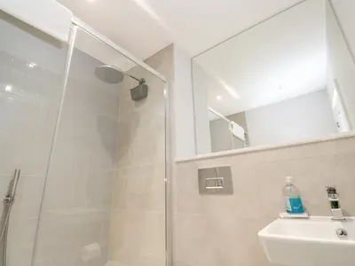 a bathroom with a shower and a sink and a mirror at Sebastian's View in Falmouth