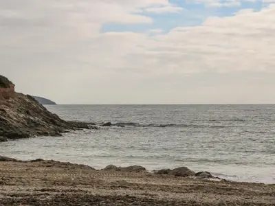a beach with rocks and the ocean on a cloudy day at Sebastian's View in Falmouth