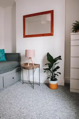 a bedroom with a chair and a mirror and a plant at Albion Cottage central Falmouth with parking and 10 minutes to the beach in Falmouth
