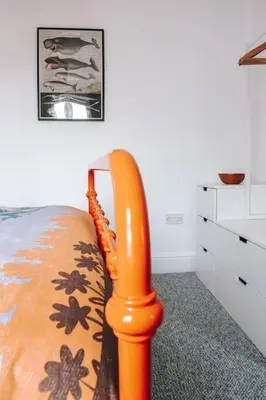 a bed with an orange bed frame in a room at Albion Cottage central Falmouth with parking and 10 minutes to the beach in Falmouth