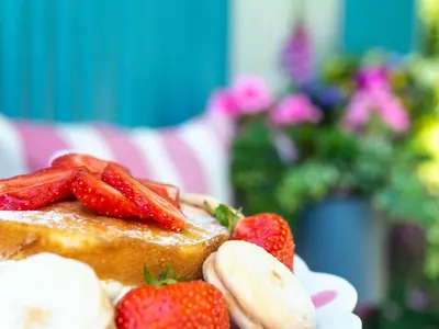 a piece of cake with strawberries and bananas on it at Gwithian Shepherds Hut in Hayle